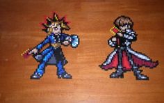 two cross stitched characters on a wooden table