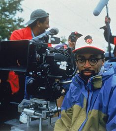 a man is standing in front of a camera and some other people are behind him