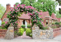 a house with pink flowers on the front gate