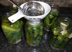 pickles and cucumbers in jars with a spoon