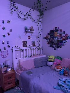 a bedroom with purple walls and pictures on the wall