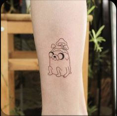 a small tattoo on the leg of a person with a dog wearing a santa hat