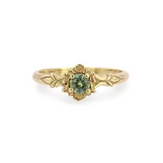 a gold ring with a green stone in the center