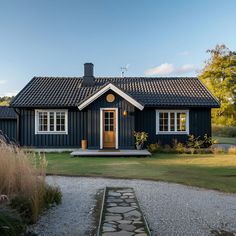 a black house with a stone pathway leading to it