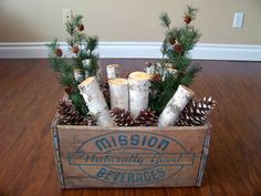 a wooden box filled with logs and pine cones on top of a hard wood floor