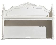 a white bed frame with an ornate headboard and foot board on the bottom shelf