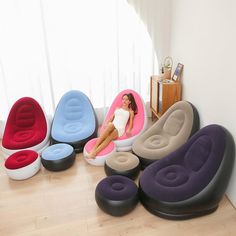 a woman sitting on an inflatable chair next to several different shaped chairs and stools