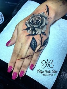 a woman's hand with a rose tattoo on it