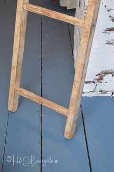 an old wooden stool sitting on top of a blue floor