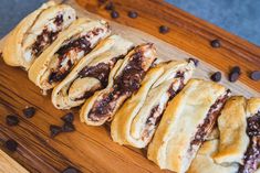 chocolate filled pastries sitting on top of a wooden cutting board