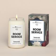 a candle that is next to a box on a table with the words room service printed on it