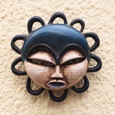 a black face mounted on the side of a wall