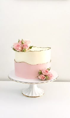 a white cake with pink frosting and flowers on top