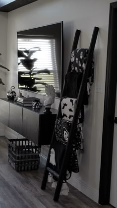 a black and white photo of a living room with a ladder leaning against the wall