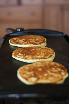 three pancakes sitting on top of a black pan