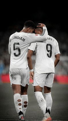 two soccer players hugging each other on the field