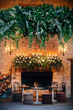 the fireplace is decorated with greenery and candles