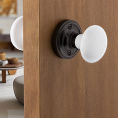 an open door with two white knobs on the front and one black button on the back