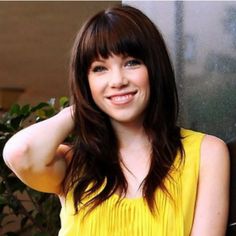 a woman in a yellow dress posing for the camera