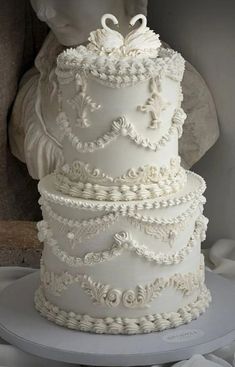 a white wedding cake with swans on top