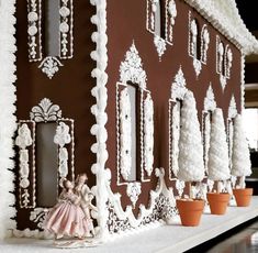 a gingerbread house is decorated with white decorations