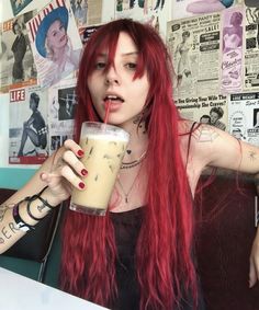 a woman with long red hair holding a drink