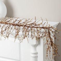 a white shelf with some branches on top of it