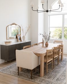 the dining room table is surrounded by beige chairs and an area rug that matches the wooden floor