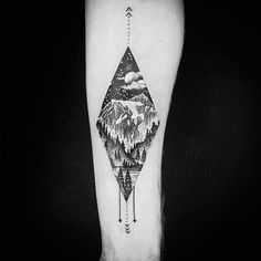 a black and white photo of a mountain landscape tattoo on the left inner forearm with an arrow