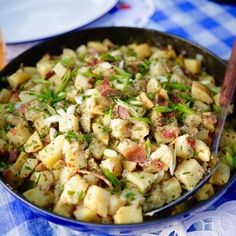 a pan filled with potato salad on top of a blue and white checkered table cloth