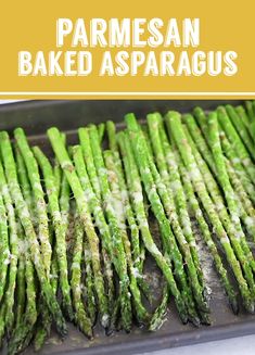 parmesan baked asparagus on a baking sheet with text overlay that reads parmesan baked asparagus