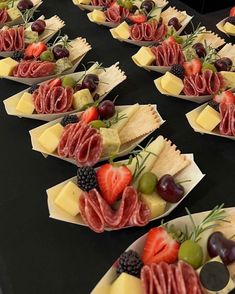 several plates with different types of food on them sitting on a black tablecloth covered table