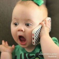 a baby holding a cell phone to its ear and making a funny face with it's mouth