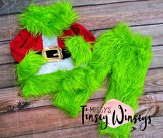 the grinch costume is laying on top of a wooden floor with his hat and gloves