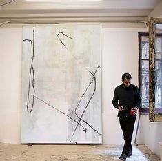 a man standing in front of a large painting