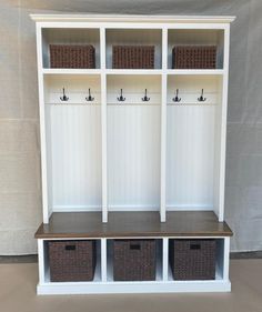 a white bookcase with three baskets on it