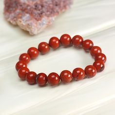 Item: RED JASPER Gemstone Unisex Crystal  Beaded Bracelet Stone: Natural Red Jasper (Chalcedony Family) Size: 7.5" (Customizable upon request) Bead Sizes Available: 4mm, 6mm, 8mm, 10mm, 12mm Location: USA (Fast delivery: 5-7 days) Special Offer: The ideal Stress Relief Gift, promoting tranquility and peace. Description 1. A Symbol of Grounding Strength Embrace the energies encapsulated within the Red Jasper bracelet, a steadfast source of grounding and reinforcing energy. Designed to bolster you Luxury Red Bracelets With Natural Stones, Affordable Red Beaded Bracelets As Gifts, Red Jasper Bracelet, Strength Bracelet, Protection Jewelry, Bracelet Stone, Bead Sizes, Yoga And Meditation, Trendy Bracelets