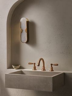 a bathroom sink with two faucets and a mirror on the wall above it