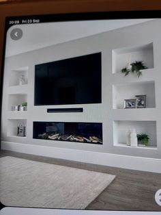 a flat screen tv mounted to the side of a wall next to a fire place