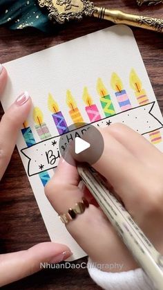 someone is drawing on a piece of paper with candles