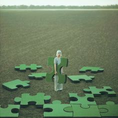 a woman standing in front of a puzzle piece