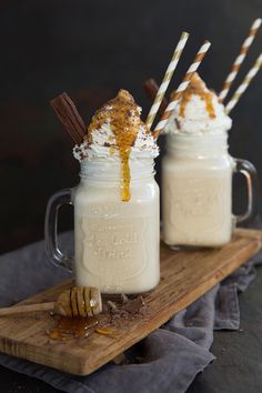 two mason jars filled with ice cream and topped with cinnamon sticks