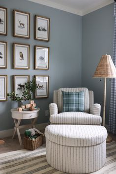 a living room with blue walls and pictures on the wall above the chair is a footstool