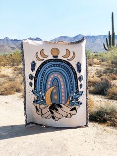 a blanket with an image of a crescent on it is in the middle of a desert