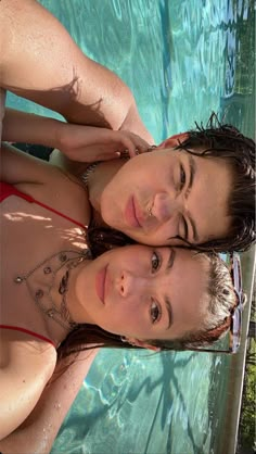 two women standing next to each other in front of a swimming pool with blue water