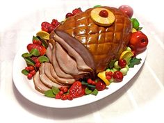 a large turkey on a white plate with fruit and berries around it's edges