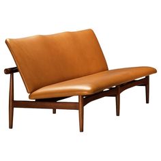 a brown leather couch sitting on top of a wooden frame with no arms and legs