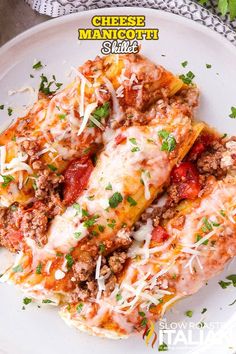 a white plate topped with lasagna covered in cheese and meat sauce on top of it