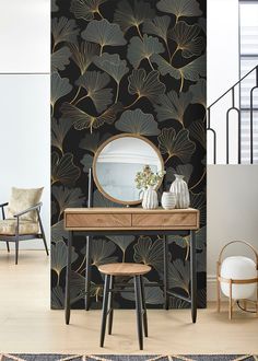 a table with a mirror and stools in front of a wallpapered room