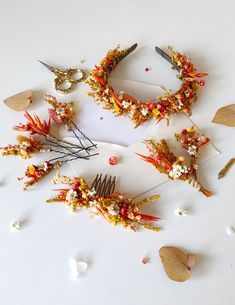 several different types of hair accessories laid out on a white surface with dried flowers and leaves